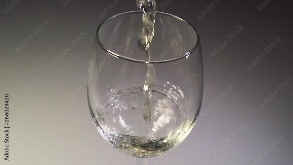 Close-up slomo shot of white wine starting to drip into a wine glass from a Bag-in-box. Close-up slomo shot of white wine starting to drip into a wine glass from a Bag-in-box.