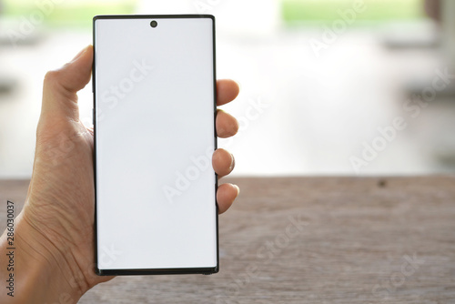 The man's hand is holding a New smartphone.