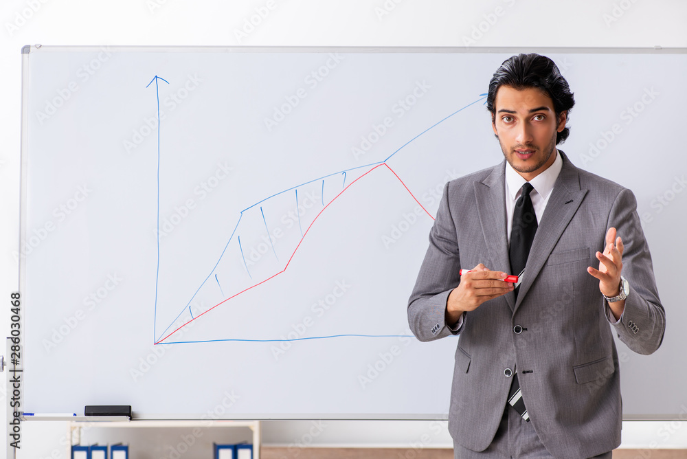 Young handsome businessman in front of whiteboard Young handsome businessman in front of whiteboard