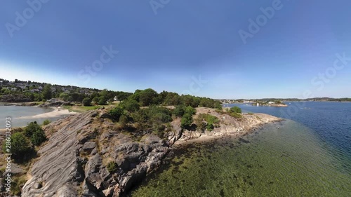 Rotating aerial panorama of Groos Park in Grimstad, Norway.  The clip begins with a tiny planet view of the area. photo