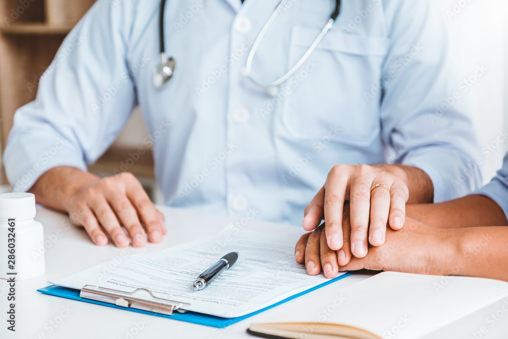 Friendly doctor hold patient hand for care and comforting Friendly doctor hold patient hand for care and comforting