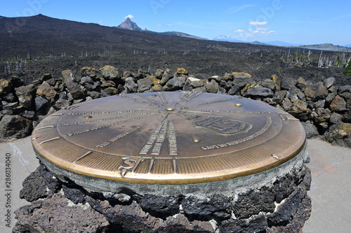 Directional cast bronze marker pointing out prominent volcanoes atop Dee Wright Observatory in Willamette National Forest, Oregon.