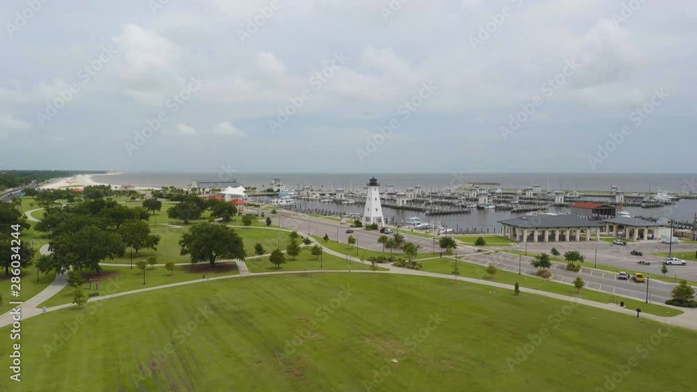 Aerial view of a lighthouse on the edge of a boat dock at a park on the edge of the ocean. Filmed in 4k 60fps and slowed to 24fps (23.976). Aerial view of a lighthouse on the edge of a boat dock at a park on the edge of the ocean. Filmed in 4k 60fps and slowed to 24fps (23.976).