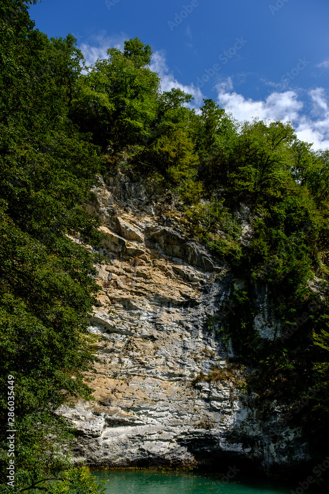 Mountain lake under the cliff in sunny day