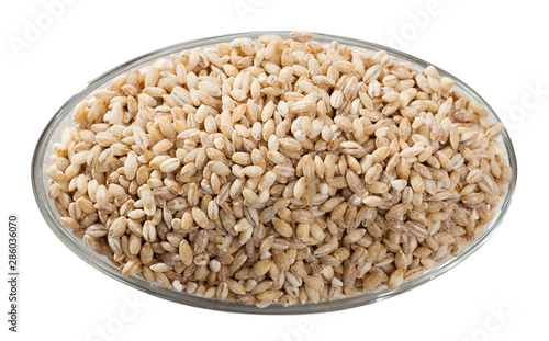 Barley groats in glass bowl on white surface , nobody