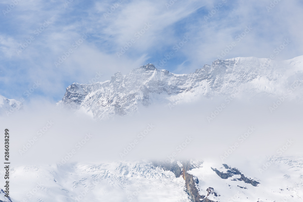 Fototapeta premium Malowniczy widok na zaśnieżone góry w pochmurny dzień, widok na zaśnieżony Matterhorn, Zermatt, Szwajcaria