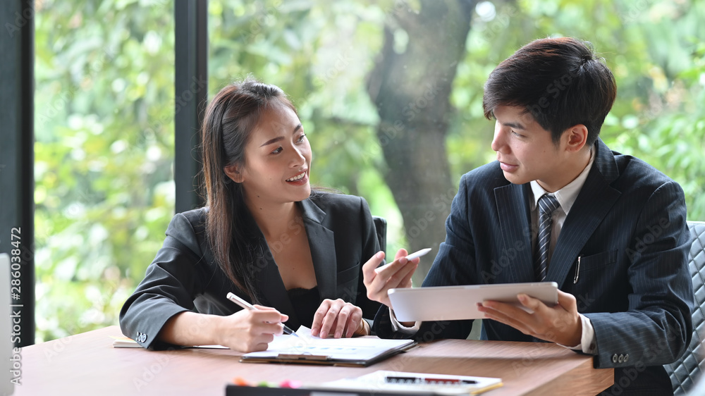 Young asian business people meeting with tablet on office table. Young asian business people meeting with tablet on office table.