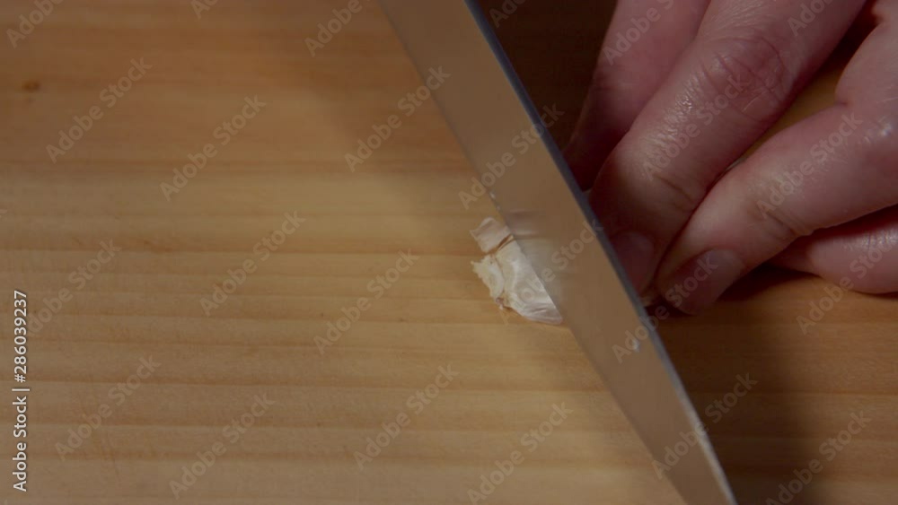 a Japanese female chef peeling the garlic clove (ingredients of Japanese style fried chicken) at her home kitchen, Tokyo, Japan. June 2019. Camera fixed, extreme close-up, high angle a Japanese female chef peeling the garlic clove (ingredients of Japanese style fried chicken) at her home kitchen, Tokyo, Japan. June 2019. Camera fixed, extreme close-up, high angle