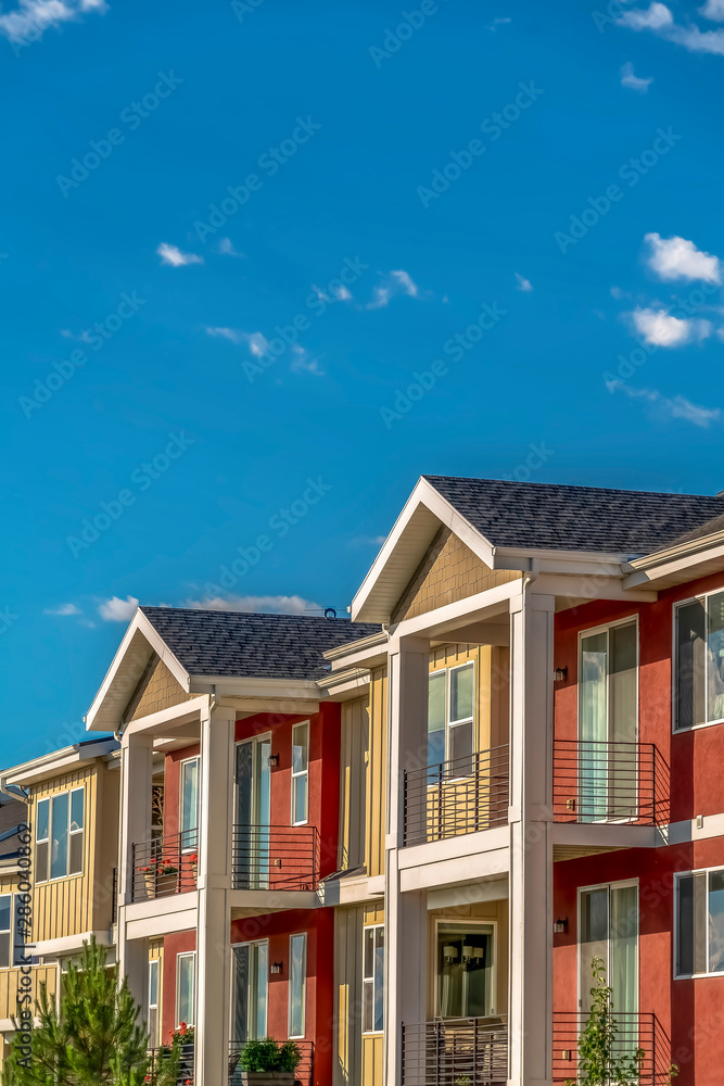 Homes with combination of red and cream exterior wall against sky on a sunny day