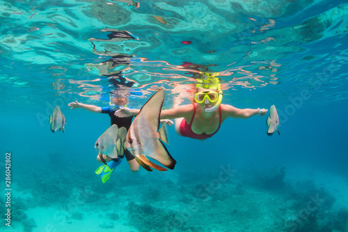 Canvas Print Happy family - mother, kid in snorkeling mask dive underwater, explore tropical fishes Platax ( Batfish)