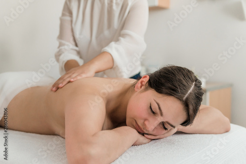 health, beauty, resort and relaxation concept - beautiful woman with closed eyes in Spa salon getting massage