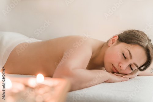 do therapeutic neck massage for a girl lying on a massage couch in a massage Spa with dark candlelight