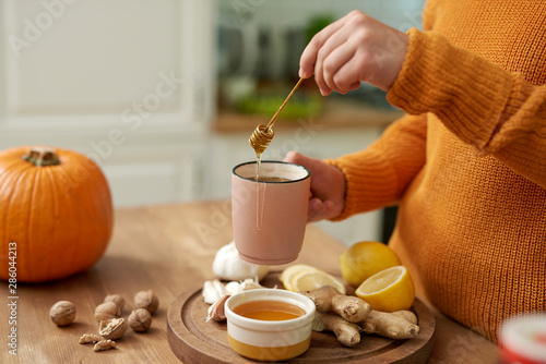 Woman making hot tea with honey