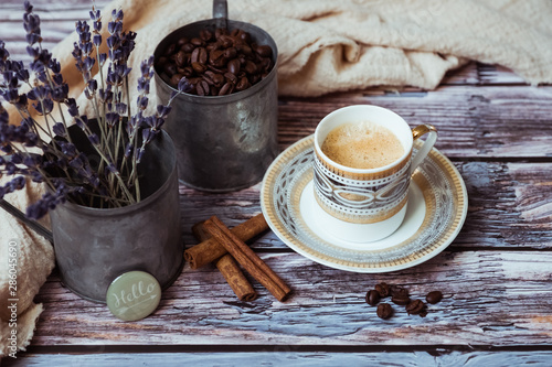Tasse de café à la cannelle, tasse en porcelaine ancienne sur une table en bois avec pots en métal lavande cannelle