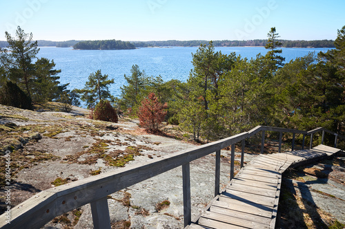 Fotografie Wooden stairs leading down from the rocks towards the sea