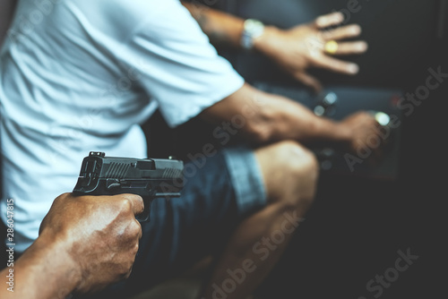 Obraz na płótnie Armed robber using the gun to robbery the money with safe background