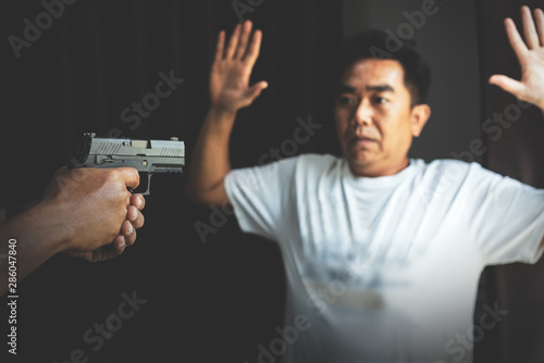 Tableau sur toile Armed robber using the gun to robbery the money with safe background