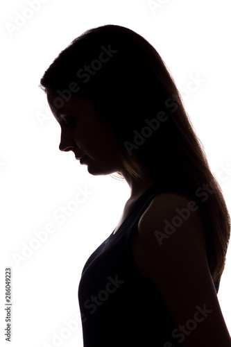Obraz na plátne Young woman look down with flowing hair - vertical silhouette