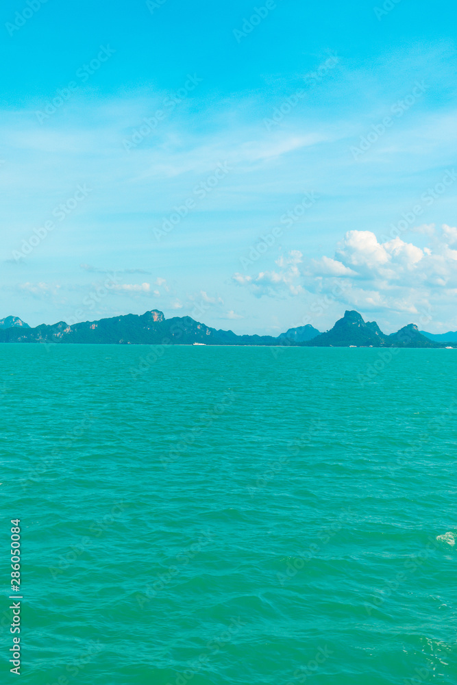 Fototapeta premium Looking at the Island, blue water and sky.
