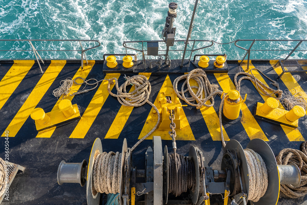 The deck of the ferry boat along with the a thick mooring rope and blue sea water wave, Thailand. Close up The deck of the ferry boat along with the a thick mooring rope and blue sea water wave, Thailand. Close up