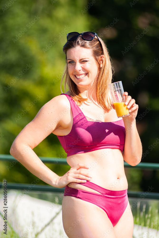 Jeune femme française dans le parc d'un hôtel buvant un jus d'orange Jeune femme française dans le parc d'un hôtel buvant un jus d'orange
