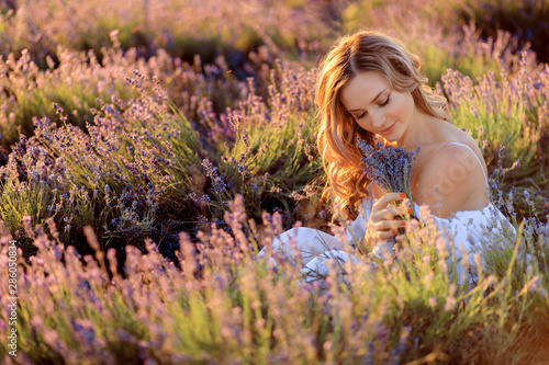 Beautiful girl on the lavender field. Beautiful woman in the lavender field on sunset.