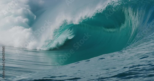 Giant blue wave breaking and barreling with amazing spray in slow motion, the world's most perfect wave, enormous empty wave breaking photo