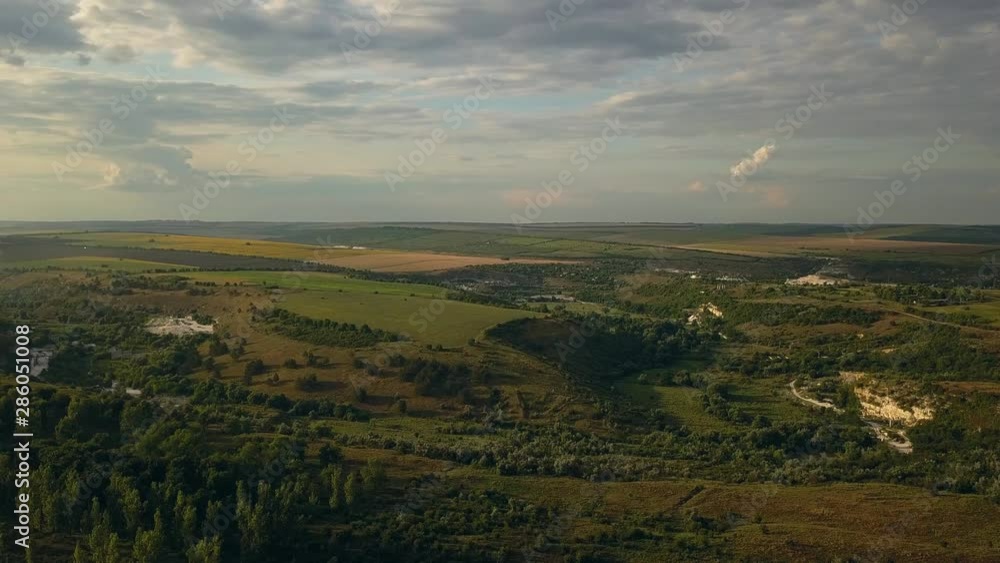 Top view drone flight over green fields and suburbs at sunset. Summer landscape Top view drone flight over green fields and suburbs at sunset. Summer landscape