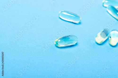 Capsules on a blue background. The concept of vitamins  fish oil  medicine  pharmaceuticals  pharmaceutical industry. Flat lay  top view