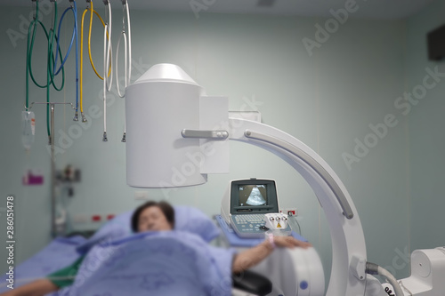 Doctors Examining Patient In Operating Room or MRI Scan room