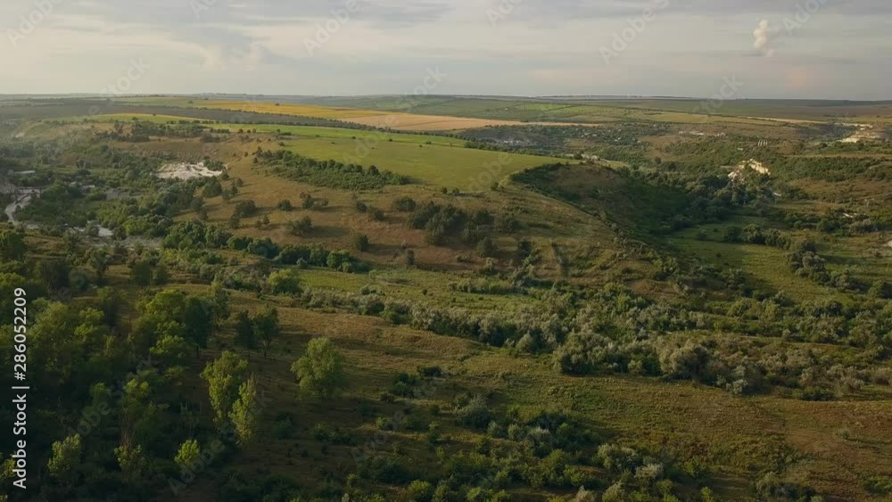 Top view drone flight over green fields and suburbs at sunset. Summer landscape Top view drone flight over green fields and suburbs at sunset. Summer landscape