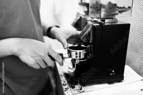 Hand preparing coffee powder for tamping in black and white