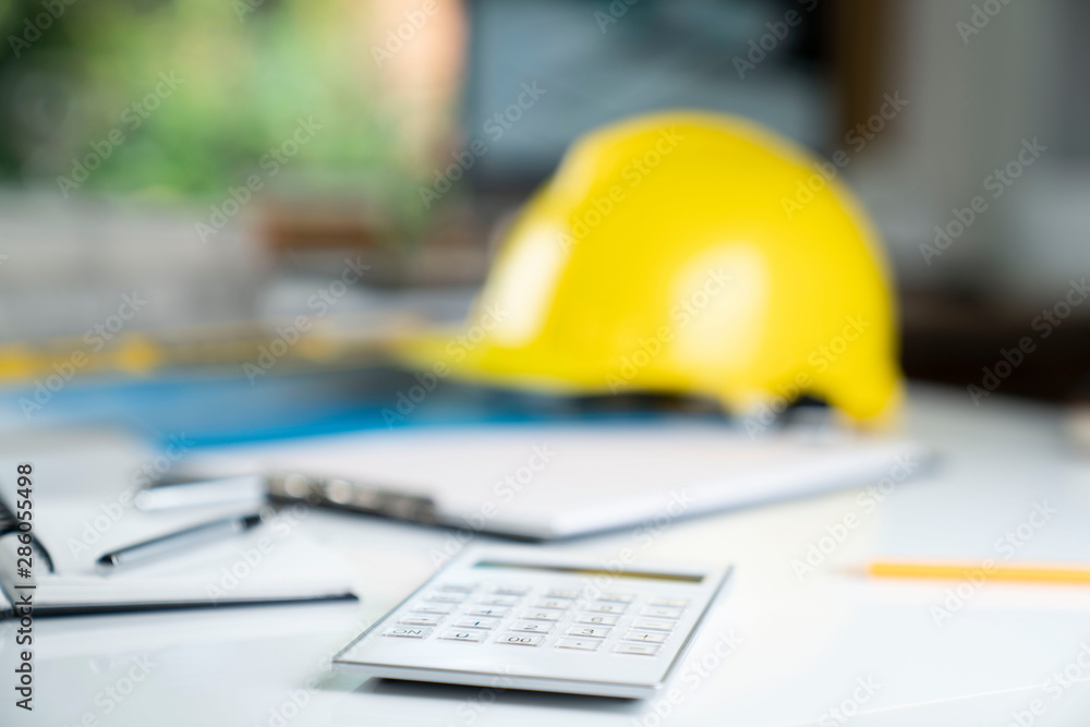 Contractor concept. Yellow hardhat, libella and plans on the white table. Contractor concept. Yellow hardhat, libella and plans on the white table.