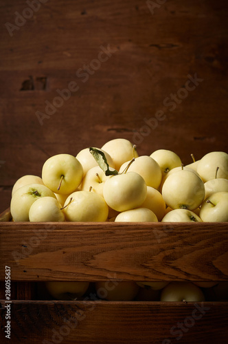 Obraz na płótnie Freshly harvested small apples in boxon wooden background w salonie