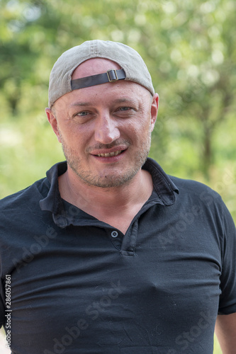 Portrait of caucasian man in a cap, outdoors, close up