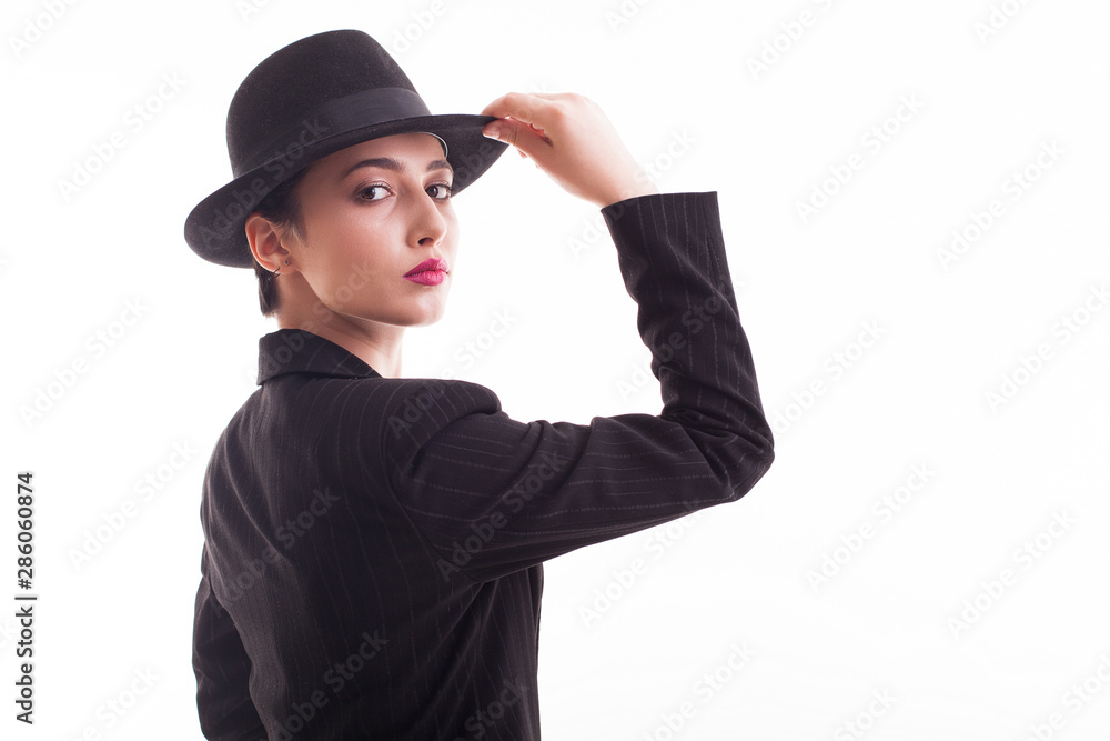 Beautiful young model with a stylish black hat over white background in studio Beautiful young model with a stylish black hat over white background in studio
