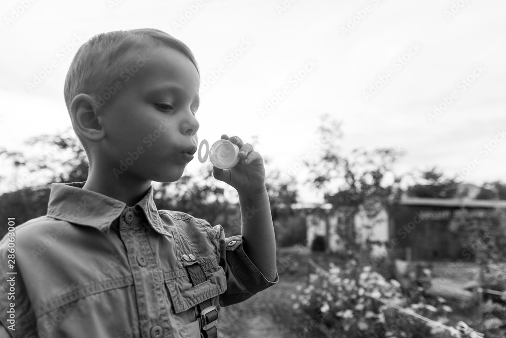 Little boy blowing bubbles. The concept of childhood.Black and white photo Little boy blowing bubbles. The concept of childhood.Black and white photo