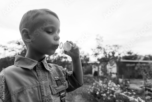Little boy blowing bubbles. The concept of childhood.Black and white photo