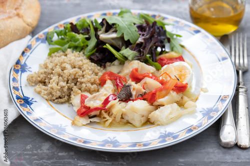 cod fish with quinoa and fresh salad on dish