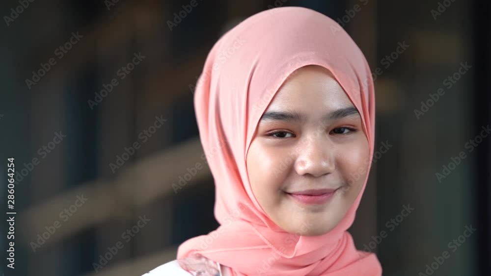 Smiling Muslim beautiful girl in hijab covering her eyes with happiness in Indonesia. Smiling Muslim beautiful girl in hijab covering her eyes with happiness in Indonesia.