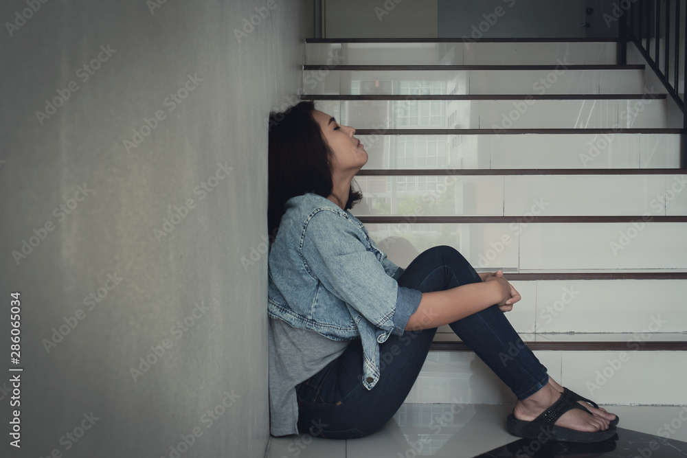 Close up sad woman sitting at staircase in apartment.Sad,depression concept. Close up sad woman sitting at staircase in apartment.Sad,depression concept.