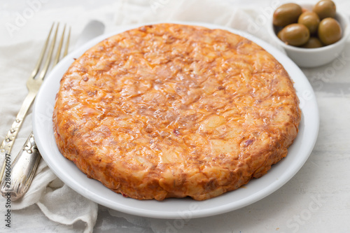 typical spanish food Tortilla with smoked meat and potato on white dish