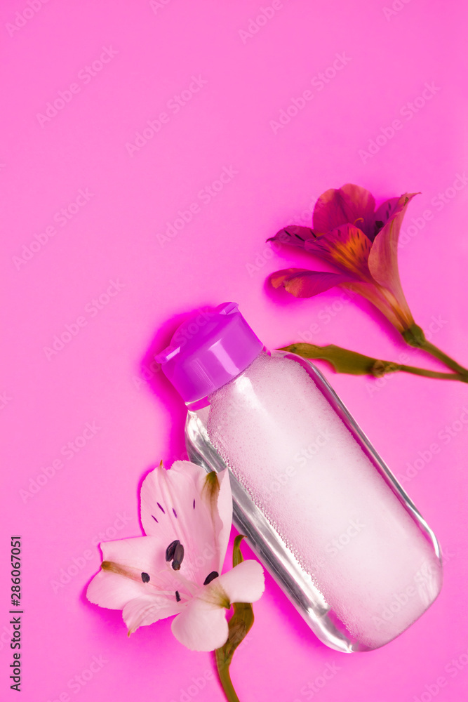 Skincare cosmetic bottle with flowers, cleansing and make-up remove, top view, pastel color background, minimalistic. Skincare cosmetic bottle with flowers, cleansing and make-up remove, top view, pastel color background, minimalistic.