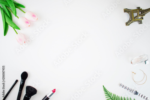 Home office workspace Women's fashion rose bouquet, fragrance and makeup brush tools on the white blackground. Fashion office desk concept.
