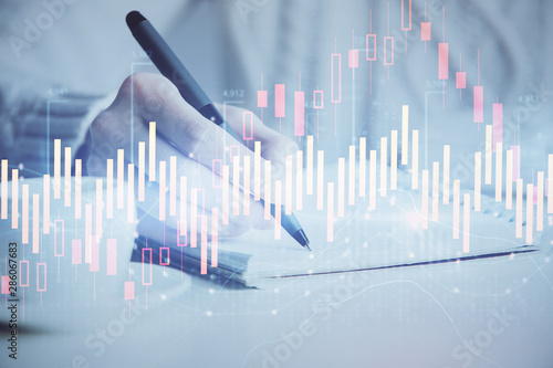 Forex chart displayed on woman's hand taking notes background. Concept of research. Double exposure © peshkova