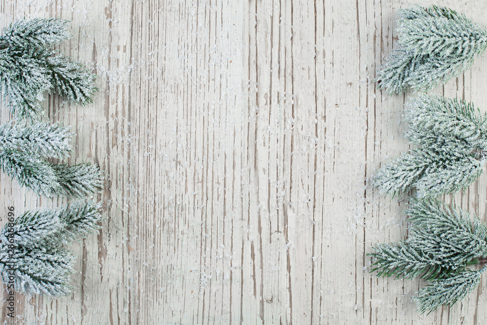 Winter and Christmas composition border with fir branch on white wooden texture background Winter and Christmas composition border with fir branch on white wooden texture background