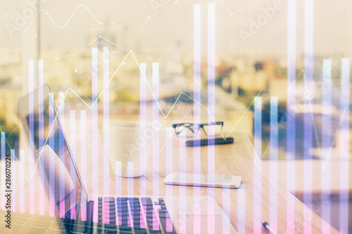 Forex graph hologram on table with computer background. Multi exposure. Concept of financial markets.