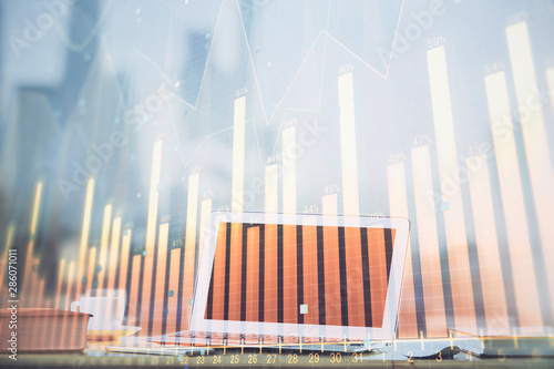 Forex graph hologram on table with computer background. Multi exposure. Concept of financial markets.