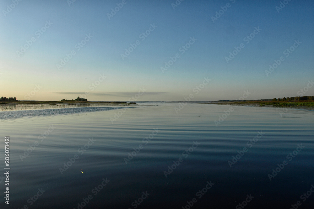Scenic sunrise panorama view, morning fog on lake, misty reflection in steaming water, Latvia Scenic sunrise panorama view, morning fog on lake, misty reflection in steaming water, Latvia