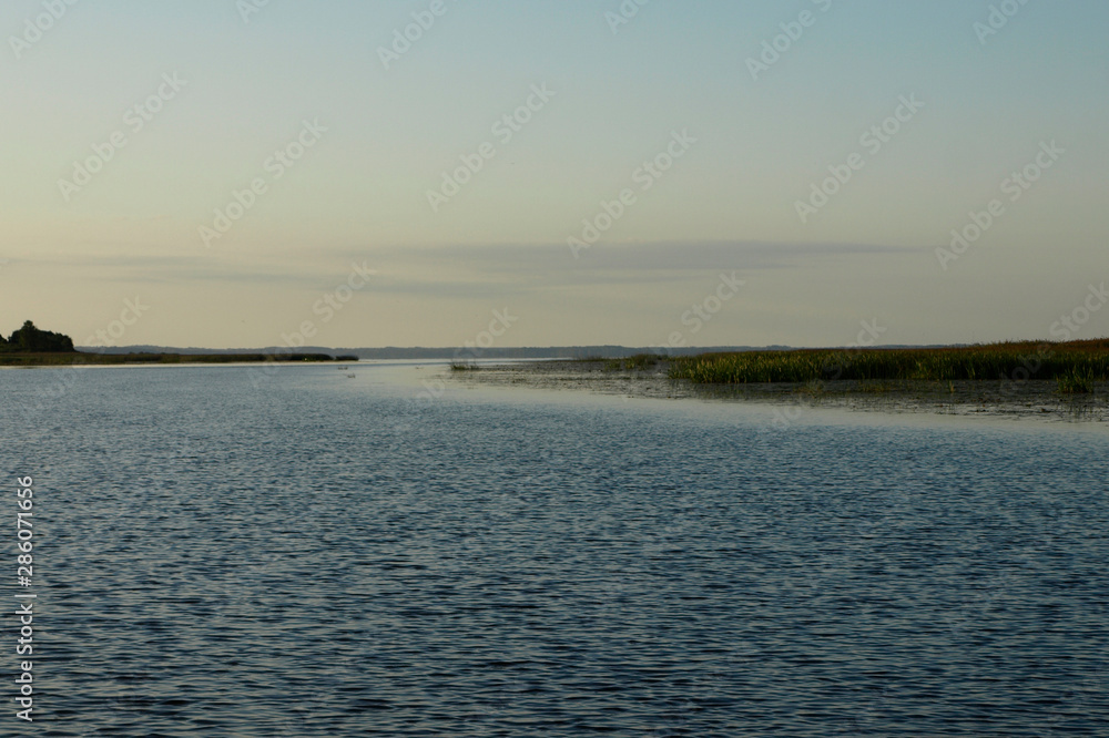 Scenic sunrise panorama view, morning fog on lake, misty reflection in steaming water, Latvia Scenic sunrise panorama view, morning fog on lake, misty reflection in steaming water, Latvia